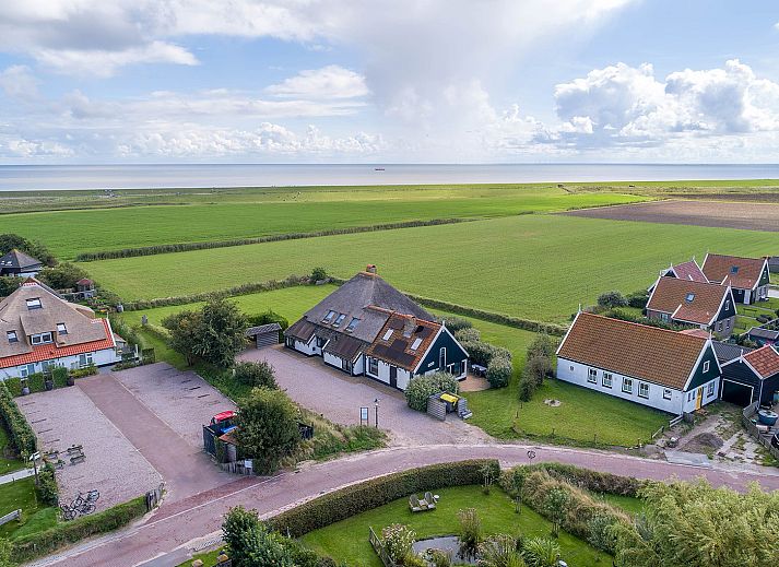 Lichte zithoek in Gouden Rijder vakantiehuis, Oosterend, Texel, met uitzicht op de tuin en moderne inrichting.