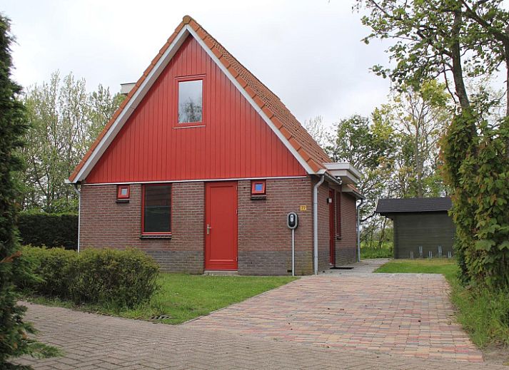 Type II+ - nr. 77 Goudvink vakantiehuis in Oosterend, Texel met rode gevel en groene tuin.