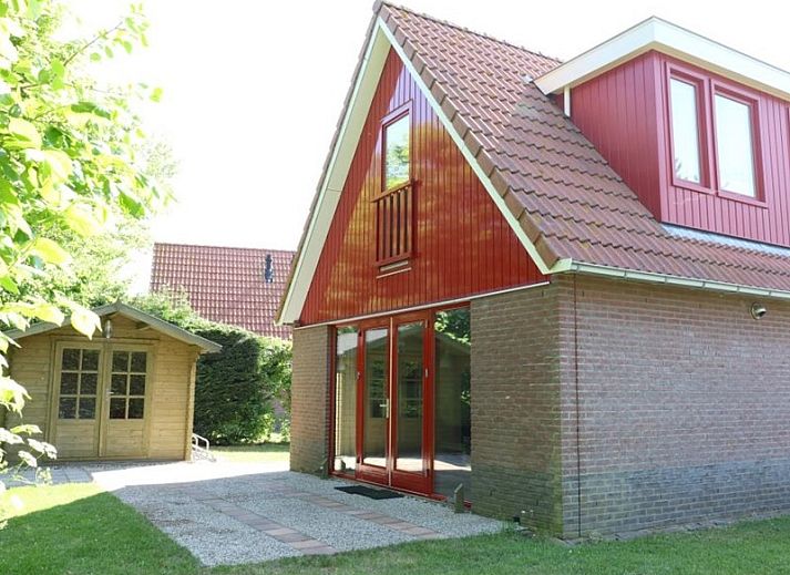 Type II+ - nr. 77 Goudvink vakantiehuis in Oosterend, Texel met rode gevel en groene tuin.