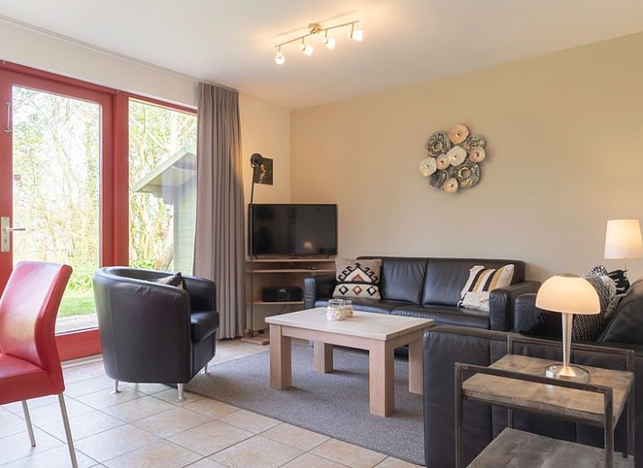 Type II+ - nr. 77 Goudvink vakantiehuis in Oosterend, Texel met rode gevel en groene tuin.