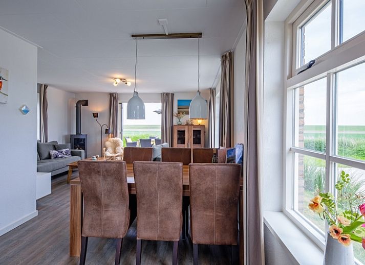 Terrasse von De Kokkel in Oosterend, Texel mit Gartenmoebeln und Sonnenschirm fuer ein entspanntes Leben im Freien.