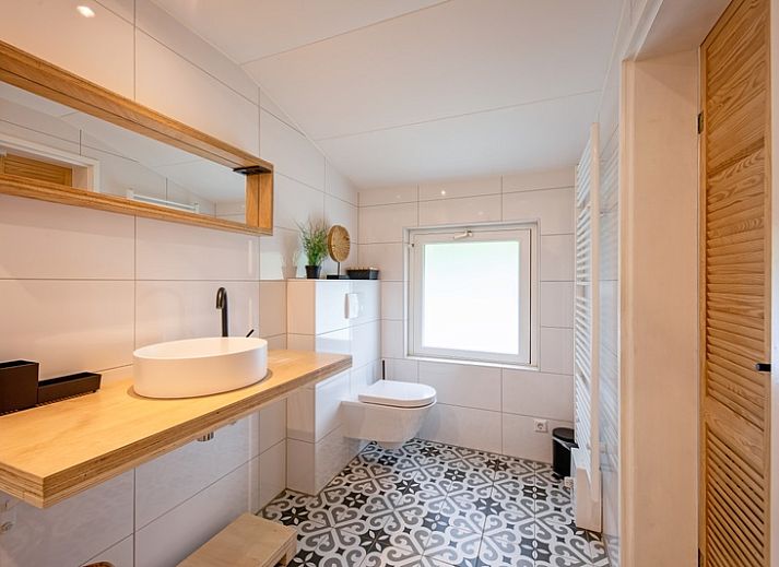 Dining and sitting area in vacation home Bungalowpark De Toes - Zeewier, Texel with modern furnishings.