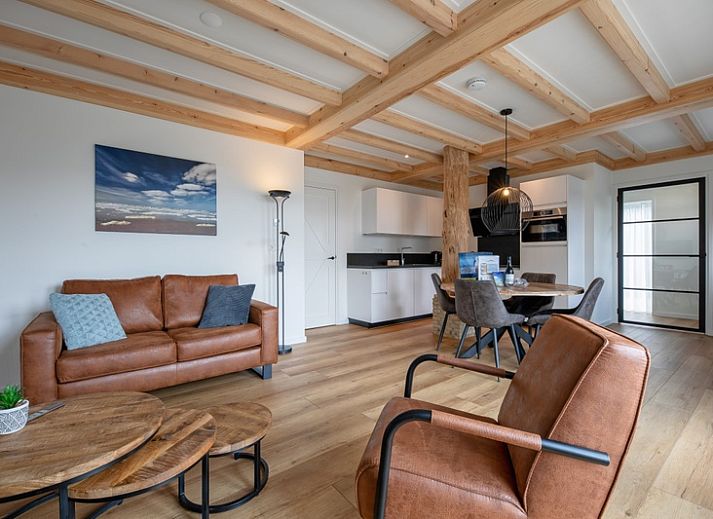 Charming exterior of Apartment C in Oudeschild, Texel, with colorful garden and terrace.