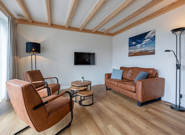 Charming exterior of Apartment C in Oudeschild, Texel, with colorful garden and terrace.