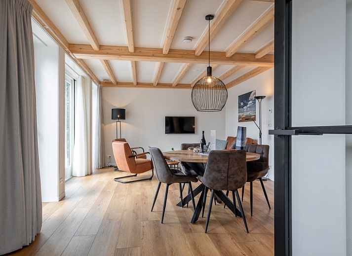 Charming exterior of Apartment C in Oudeschild, Texel, with colorful garden and terrace.