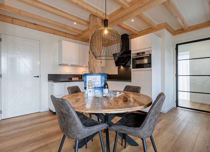 Cozy living room of Apartment C, Texel, with wooden beams and modern furnishings.