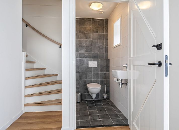 Cozy living room of Apartment C, Texel, with wooden beams and modern furnishings.