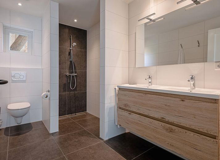 Cozy living room of Apartment C, Texel, with wooden beams and modern furnishings.