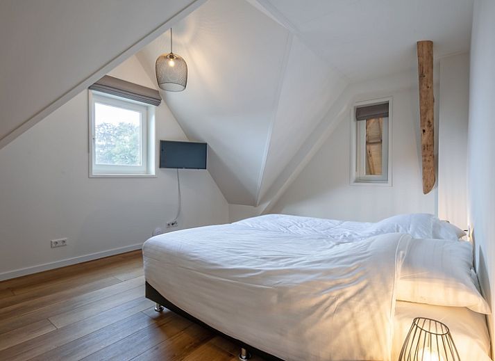 Cozy living room of Apartment C, Texel, with wooden beams and modern furnishings.