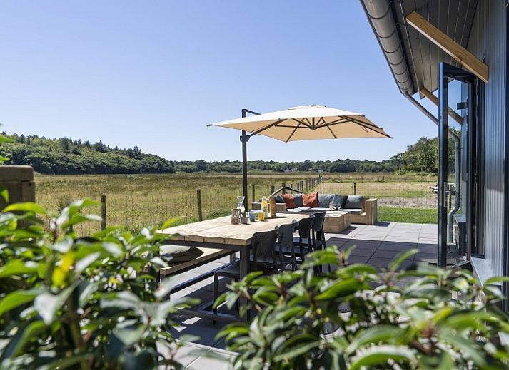 Rovershut - Family House 1 in Dennenbos, Texel bietet ein charmantes Ferienhaus inmitten bunter Blumen und gruener Natur.