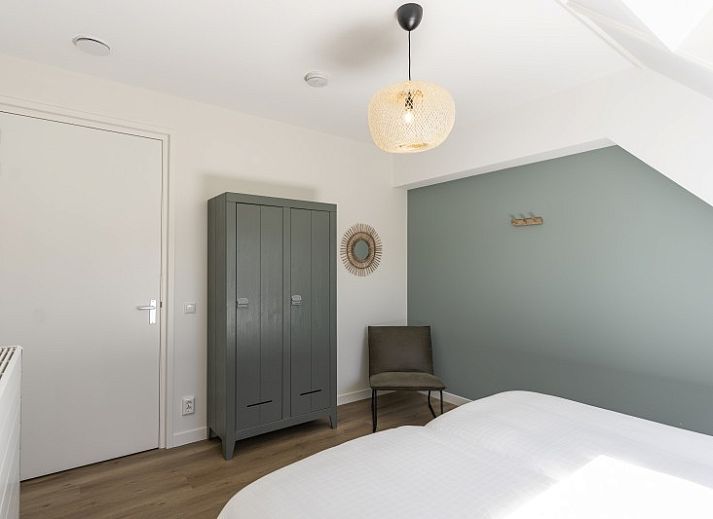 Innenraum von Rovershut - Familienhaus 1 in Dennenbos, Texel. Modernes Esszimmer im Ferienhaus mit grossem Esstisch und stilvoller Beleuchtung.