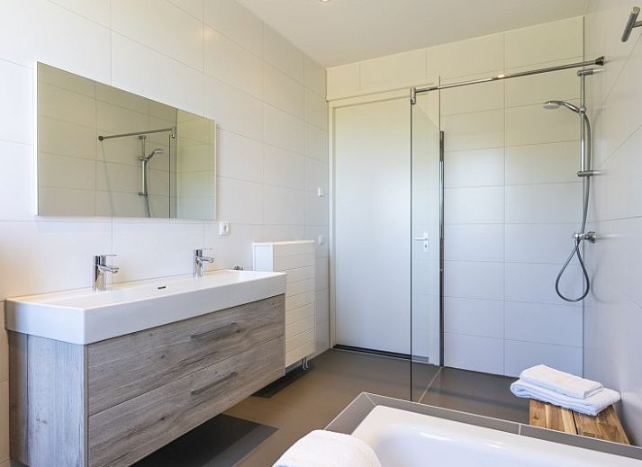 Innenraum von Rovershut - Familienhaus 1 in Dennenbos, Texel. Modernes Esszimmer im Ferienhaus mit grossem Esstisch und stilvoller Beleuchtung.