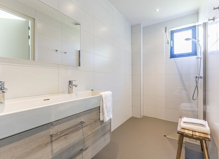 Innenraum von Rovershut - Familienhaus 1 in Dennenbos, Texel. Modernes Esszimmer im Ferienhaus mit grossem Esstisch und stilvoller Beleuchtung.