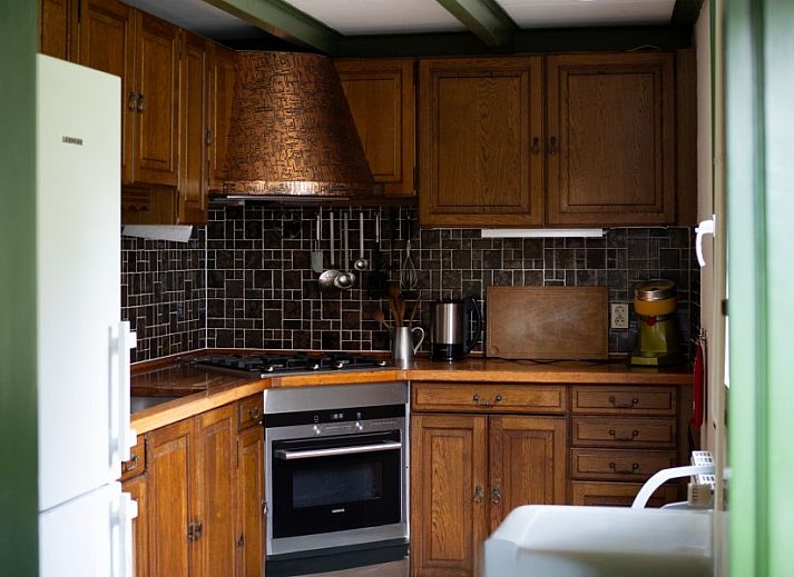 Rustikale Terrasse im Ferienhaus Het Ruge Landje in Dennenbos Texel mit gruenem Garten.