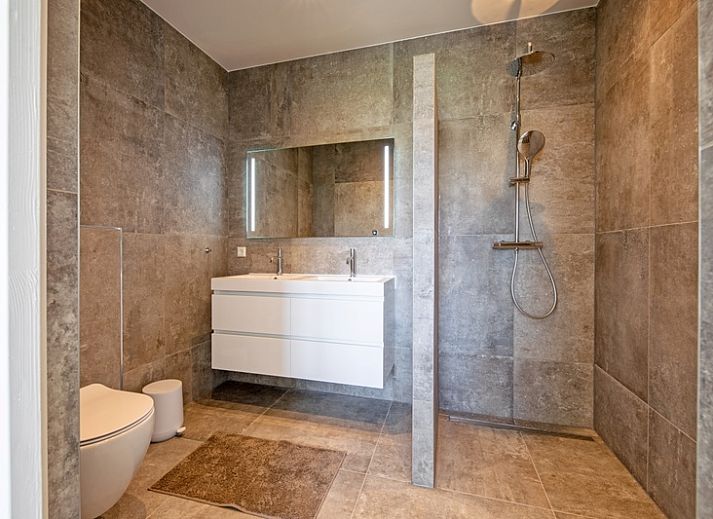 Gemuetliches Wohnzimmer im Ferienhaus De Zuidbunder auf Texel mit bequemem Sofa und moderner Einrichtung.