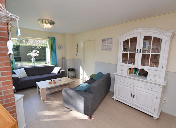 Buitenzijde van Vakantiehuis De Nagtegaal 15, De Wulk in De Dennen, Texel, omgeven door groene natuur.