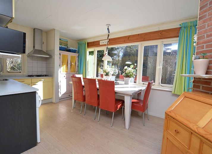 Buitenzijde van Vakantiehuis De Nagtegaal 15, De Wulk in De Dennen, Texel, omgeven door groene natuur.