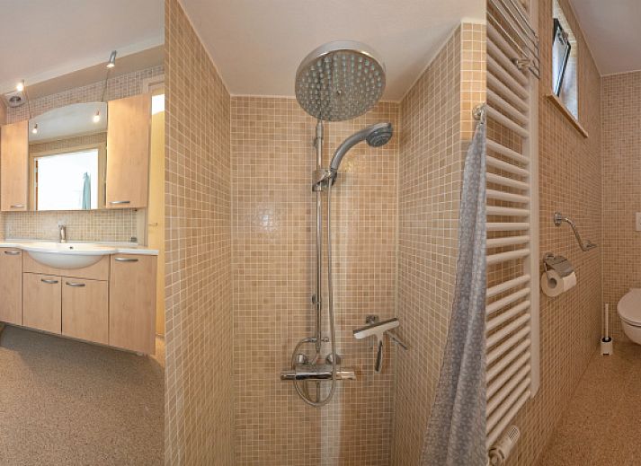 Lichte woonkamer van Huisje 7 in De Dennen, Texel met comfortabele zithoek en uitzicht op de natuur van de Waddeneilanden.