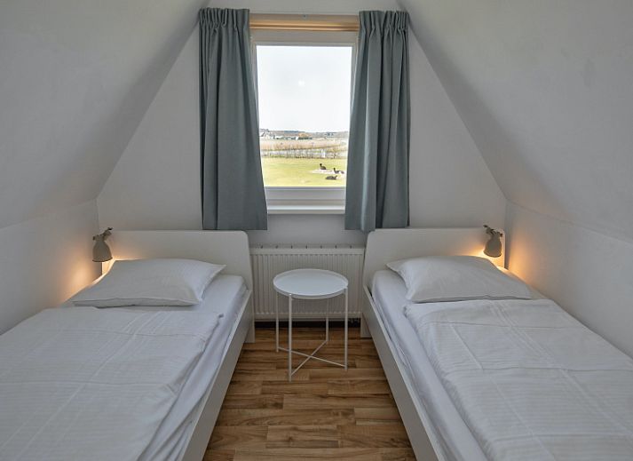 Lichte woonkamer van Huisje 7 in De Dennen, Texel met comfortabele zithoek en uitzicht op de natuur van de Waddeneilanden.