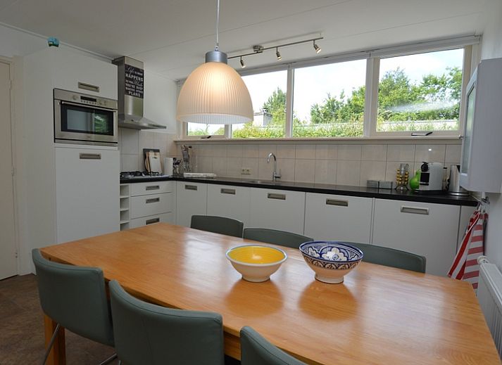 Vakantiehuis de Parel 182 in De Dennen, Texel met zonnig terras en groene omgeving.