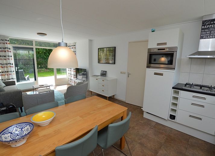 Lichte woonkamer van Vakantiehuis de Parel 182 in De Dennen, Texel met uitzicht op de tuin.