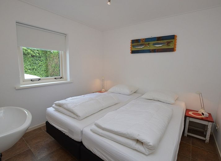 Lichte woonkamer van Vakantiehuis de Parel 182 in De Dennen, Texel met uitzicht op de tuin.