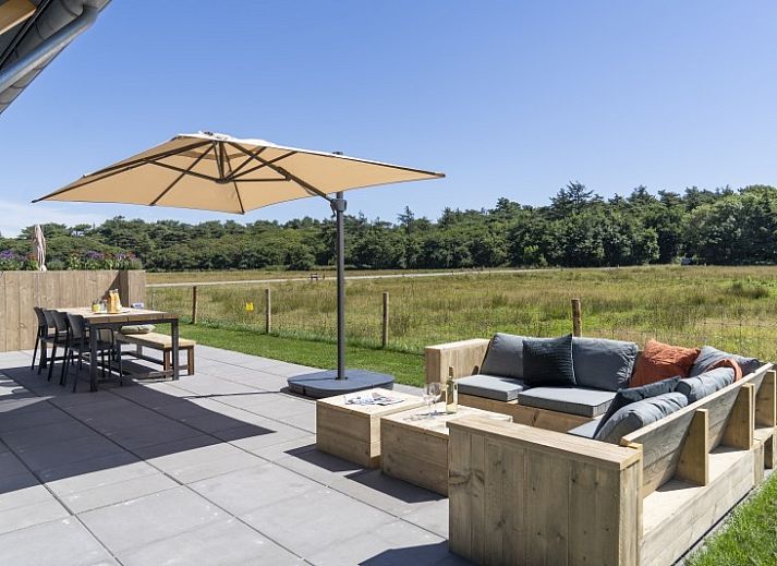 Rovershut - Familiehuis 2, een modern vakantiehuis in De Dennen, Texel, met ruime tuin en blauwe lucht.