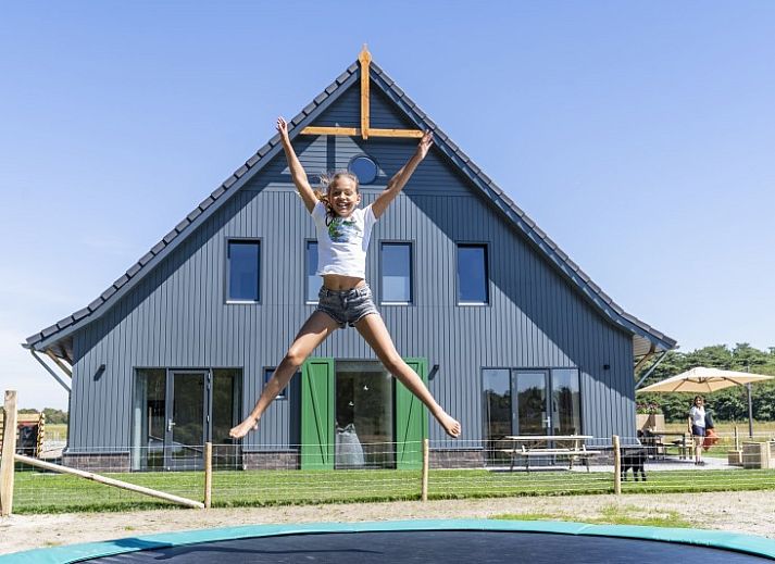 Rovershut - Familiehuis 2, een modern vakantiehuis in De Dennen, Texel, met ruime tuin en blauwe lucht.