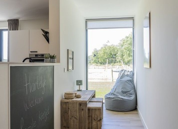 Terras van Rovershut - Familiehuis 2 in De Dennen, Texel, met comfortabele loungebank en weids uitzicht op de natuur.