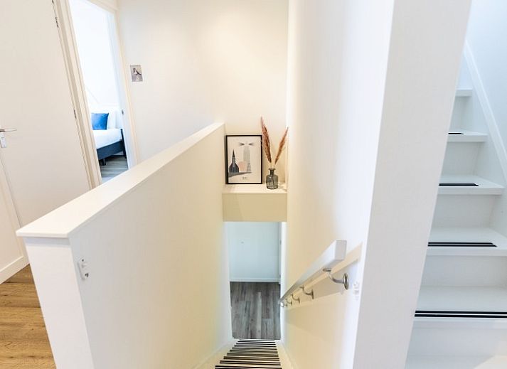 Buitenterras van Rovershut - Familiehuis 2 in De Dennen, Texel, met zithoek en eettafel onder een parasol.