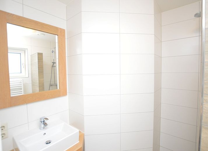 Gemuetliches Wohnzimmer des Ferienhauses de Parel 150 in De Dennen, Texel mit komfortabler Sitzecke.