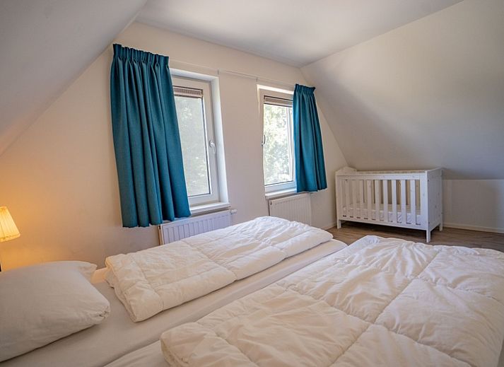 Innenraum Ferienhaus de Parel 150 in De Dennen, Texel mit Sitzecke und grossen Fenstern.