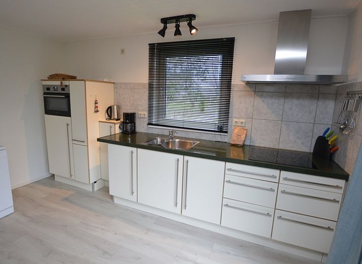 Bungalowpark Vredelust in De Dennen, Texel biedt een charmant vakantiehuis met een zonnig terras en groene omgeving.