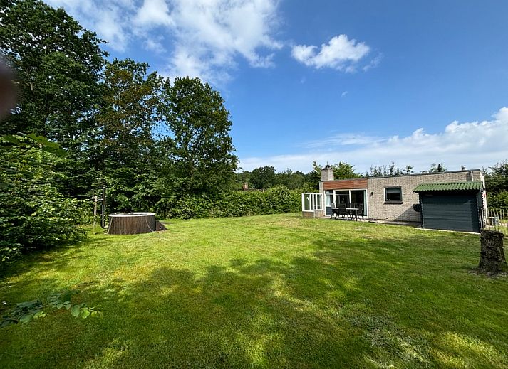 Ruime tuin van vakantiehuis de Parel 162 in Bungalowpark de Parel, De Dennen, Texel, omgeven door groen.