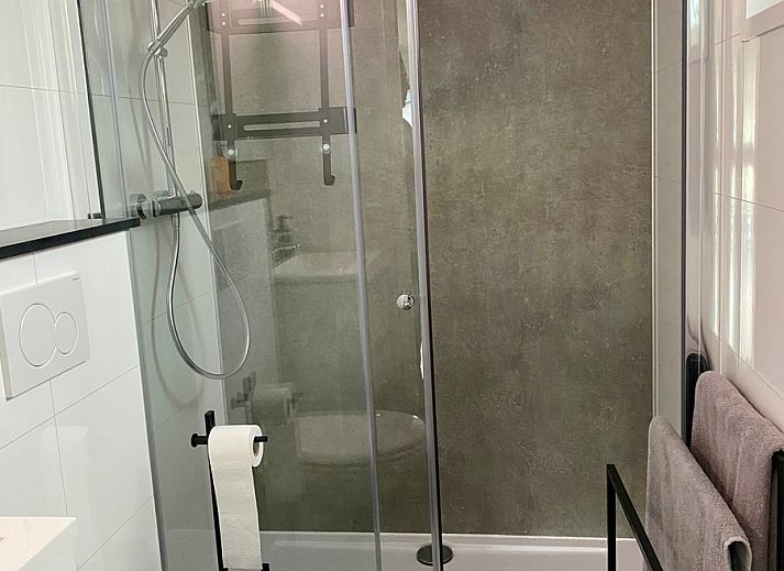 Lichte woonkamer in Vakantiepark de Bremakker - Bosveld 148, De Dennen, Texel met grote ramen en uitzicht op groen.