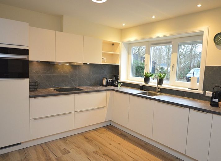 Gemuetliches Wohnzimmer des Ferienhauses De Nagtegaal 23 in De Dennen Texel mit bequemer Sitzecke.