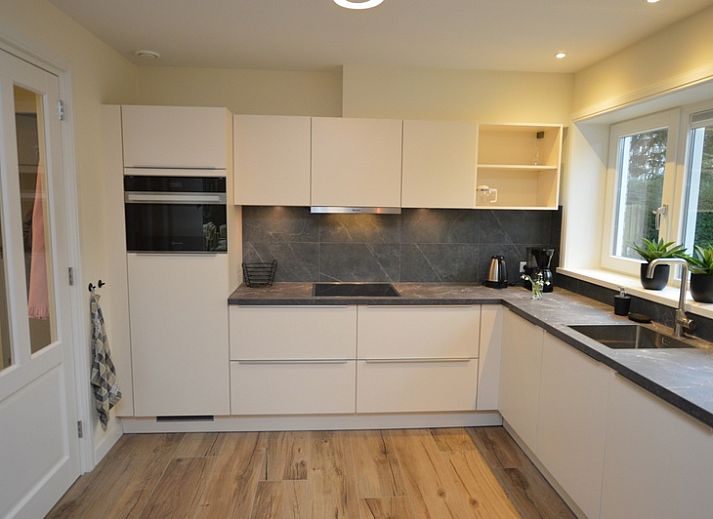 Gemuetliches Wohnzimmer des Ferienhauses De Nagtegaal 23 in De Dennen Texel mit bequemer Sitzecke.