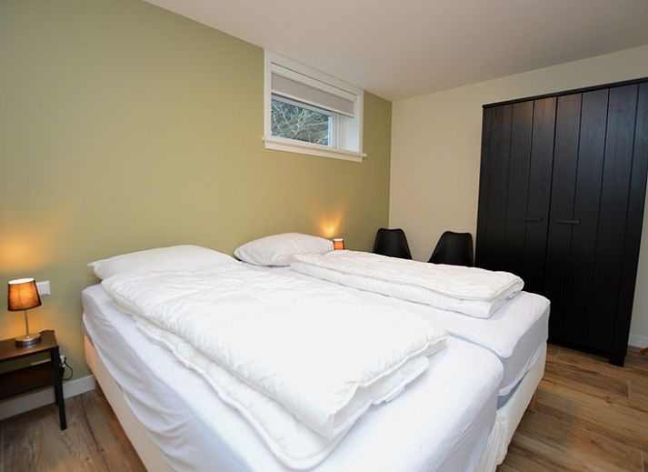 Gemuetliches Wohnzimmer des Ferienhauses De Nagtegaal 23 in De Dennen Texel mit bequemer Sitzecke.