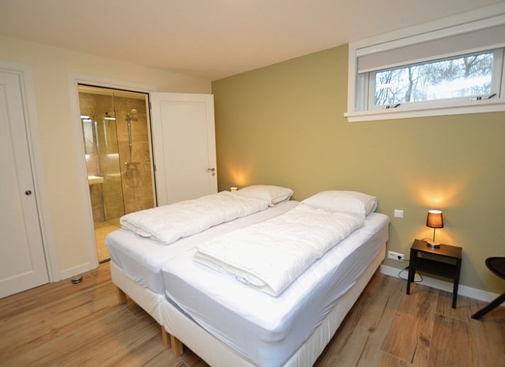 Helles Wohnzimmer im Ferienhaus De Nagtegaal 23, De Dennen Texel, mit moderner Einrichtung und Blick auf den Garten.