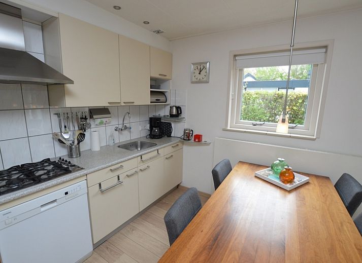 Helles Wohnzimmer des Ferienhauses de Parel 192 in De Dennen, Texel mit bequemen Sitzgelegenheiten und Blick auf den Garten.