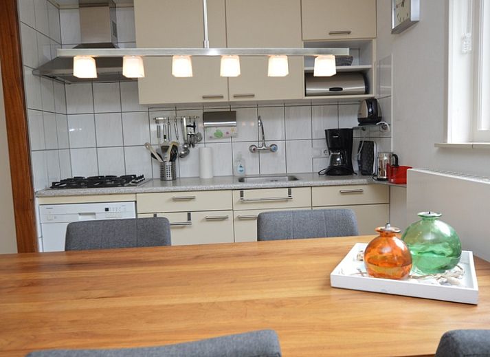 Helles Wohnzimmer des Ferienhauses de Parel 192 in De Dennen, Texel mit bequemen Sitzgelegenheiten und Blick auf den Garten.