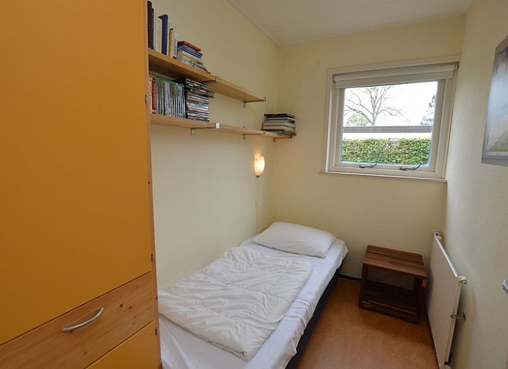 Helles Wohnzimmer des Ferienhauses de Parel 192 in De Dennen, Texel mit bequemen Sitzgelegenheiten und Blick auf den Garten.