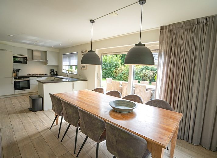 Gemuetliches Wohnzimmer des Ferienhauses de Parel 152 in De Dennen, Texel mit Blick auf den Garten.