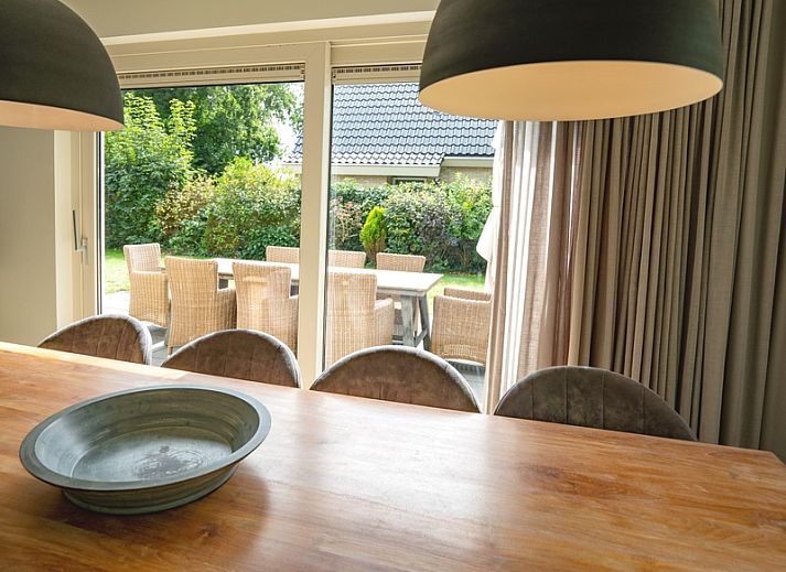 Gemuetliches Wohnzimmer des Ferienhauses de Parel 152 in De Dennen, Texel mit Blick auf den Garten.