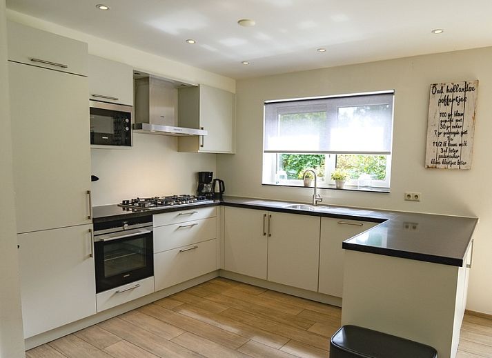 Gemuetliches Wohnzimmer des Ferienhauses de Parel 152 in De Dennen, Texel mit Blick auf den Garten.