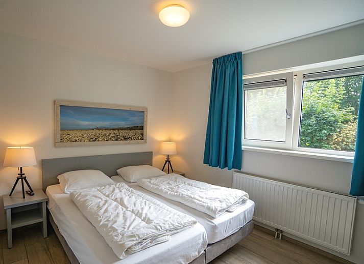 Gemuetliches Wohnzimmer des Ferienhauses de Parel 152 in De Dennen, Texel mit Blick auf den Garten.