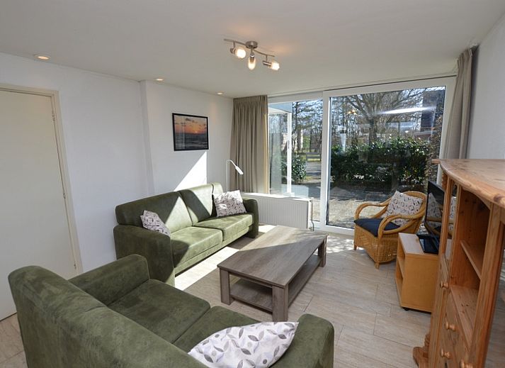 Das Ferienhaus de Parel 198 in De Dennen, Texel, bietet eine ruhige Aussicht auf die gruene Umgebung und den blauen Himmel.