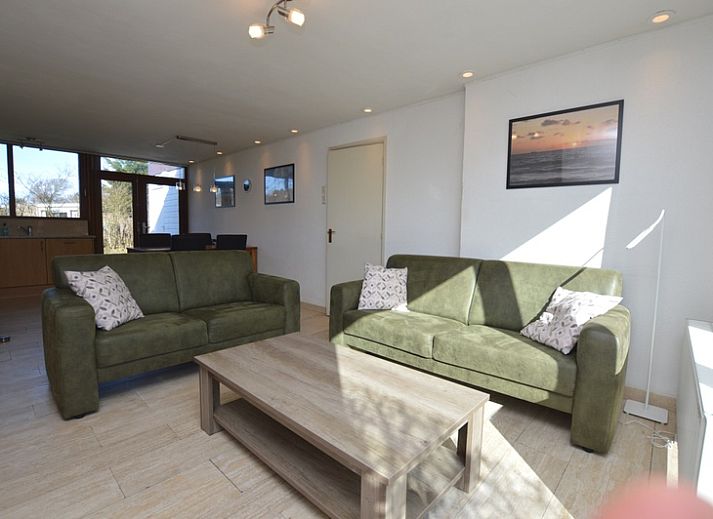 Das Ferienhaus de Parel 198 in De Dennen, Texel, bietet eine ruhige Aussicht auf die gruene Umgebung und den blauen Himmel.