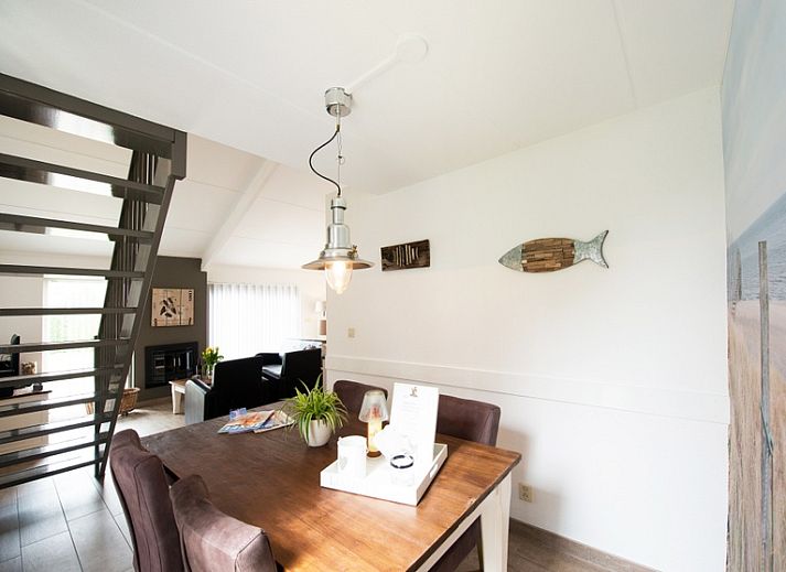 Aussenansicht des Ferienhauses Gortersmient 304, De Dennen, Texel mit schoener Terrasse und gruener Umgebung.