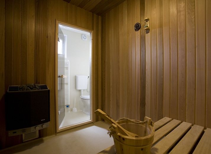 Villetta Sauna vakantiehuis met houten terras in De Dennen, Texel, Waddeneilanden omgeven door natuur.